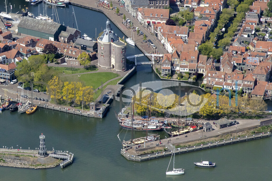 Een luchtopname van de haven met (M) De Drommedaris, het was de zuidelijke toegangspoort van de stad Enkhuizen. Het gebouw is neergezet als verdedigingswerk bij de ingang van de Oude Haven.